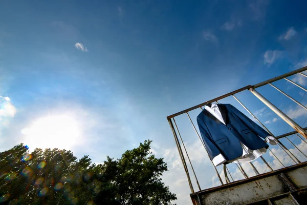 Groom suit hanged with blue sky and clouds