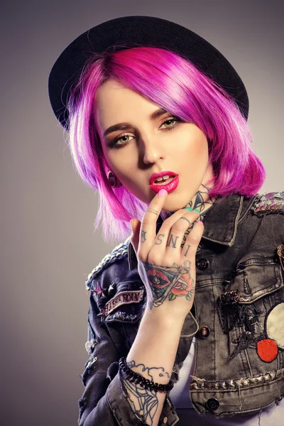 现代年轻的女孩,明亮的深红色头发。纹身。牛