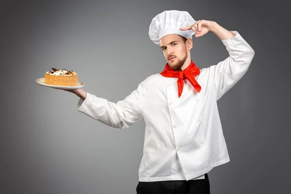 Confectionery. Portrait of a male confectioner cooking a delicious cake.