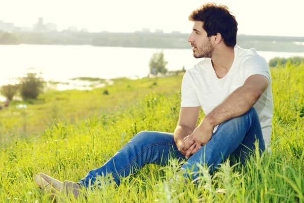 Optimistic look. Handsome young man sitting relaxed