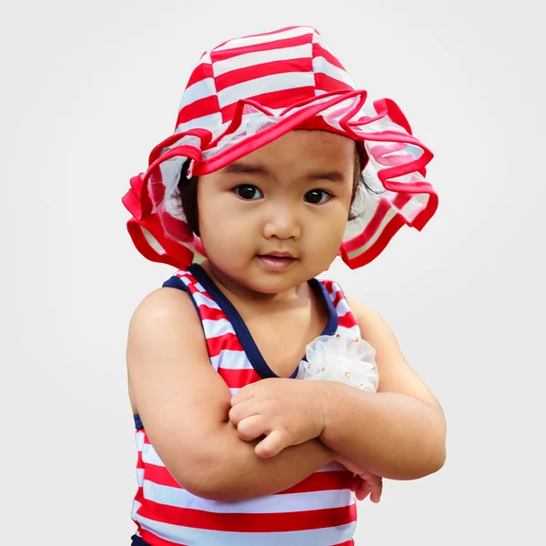 Confident asian cute baby in hat with arm cross