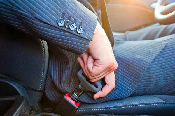 Driver in business suit fastens his seat himself automobile seat belt