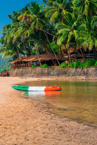 Sandy beach in the tropics and canoes by the river