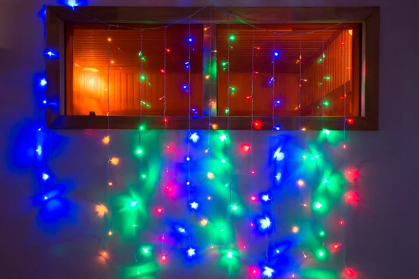Multi-colored Christmas lights lit on the window