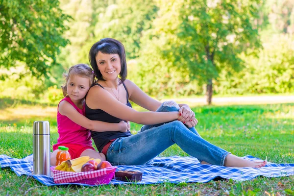 Happy family on a picnic in the green lawn