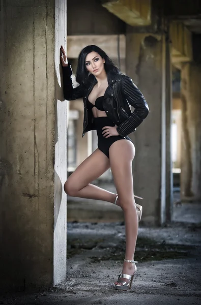 depositphotos_105268142-Portrait-of-beautiful-sexy-young-woman-with-black-outfit-leather-jacket-over-lingerie-in-urban-background.-Attractive-brunette-with-perfect-long-legs-on-high-heels-silver-sandals-posing-fashion..jpg