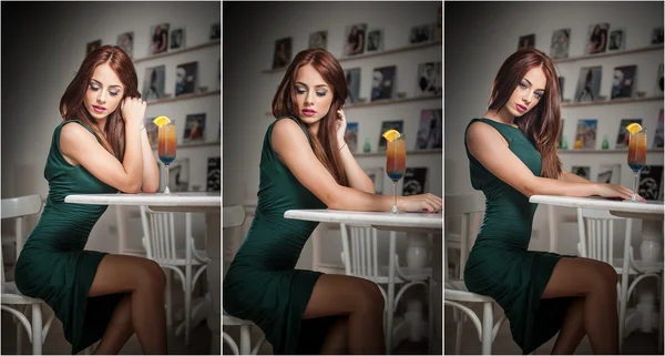 Fashionable attractive young woman in green dress sitting in restaurant. Beautiful redhead posing in elegant scenery with an orange juice glass on the table. Pretty female relaxing, indoor shot.