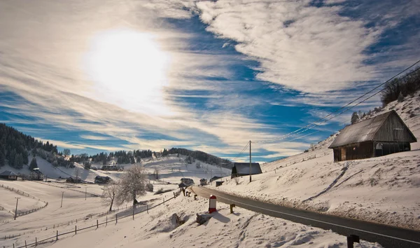 Majestic sunset in the mountains landscape. Sunset landscape in Carpathian mountains. Dawn in mountains Carpathians, Romania. Mountains covered with snow. Mountain road