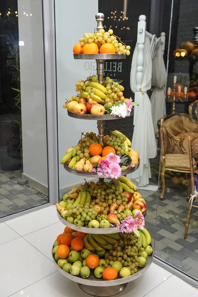 Fruits arrangement. Fresh various fruits elegant decoration. Assortment of exotic fruits. Multicolored fruits. Wedding decoration with fruits in restaurant, apples,bananas, oranges, grapes, nectarines