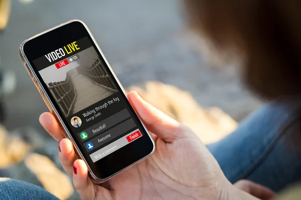 Woman sitting in street watching live video