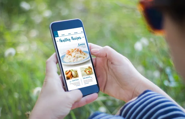 Girl holding smartphone with healthy recipes