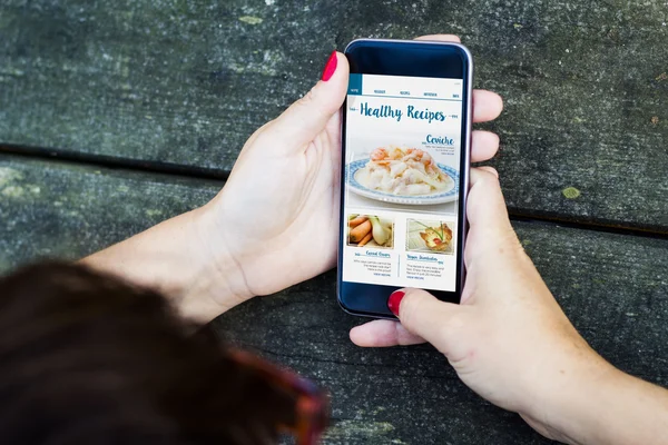 Woman using smartphone to check recipes
