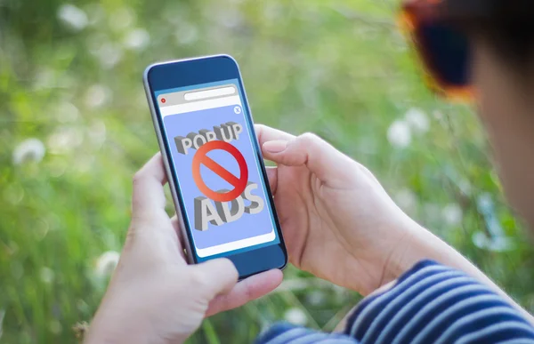 Girl holding smartphone with ads blocker