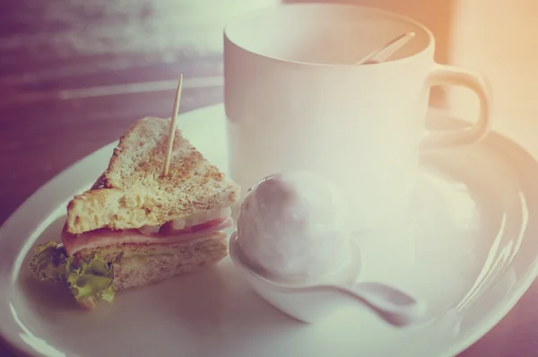 Coffee with dumplings in coconut cream  and sandwich Bologna sausage