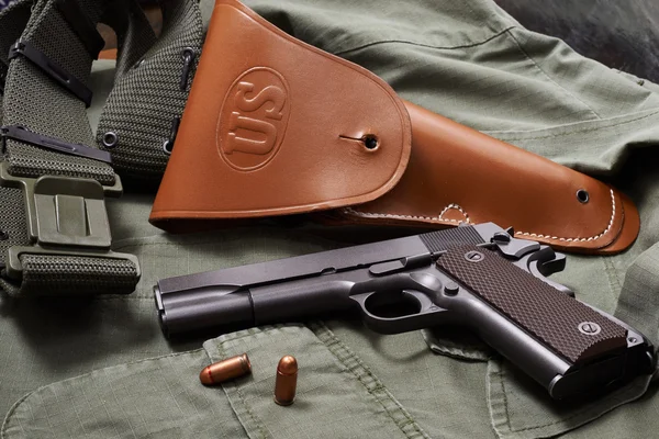 Colt pistol, holster and belt lie on military jacket