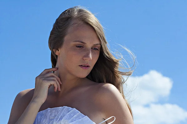 Portrait of attractive young woman holding her hand at neck