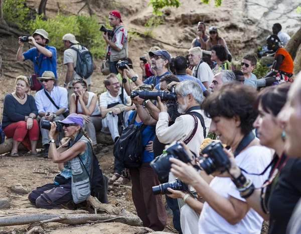 Tourists take pictures of preparation for bull jumping ceremony.