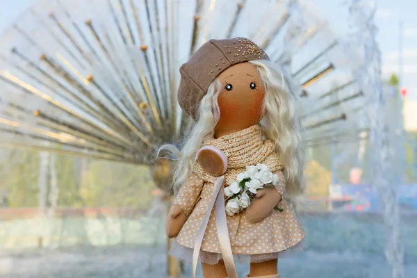 Textile doll with real hair dressed in a beige dress and a beret