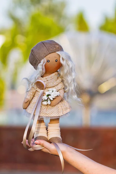 Textile doll with real hair dressed in a beige dress and a beret