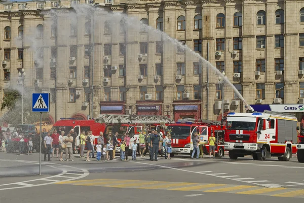 Fire engines at the exhibition under the open sky demonstrate the possibility of a fire hose