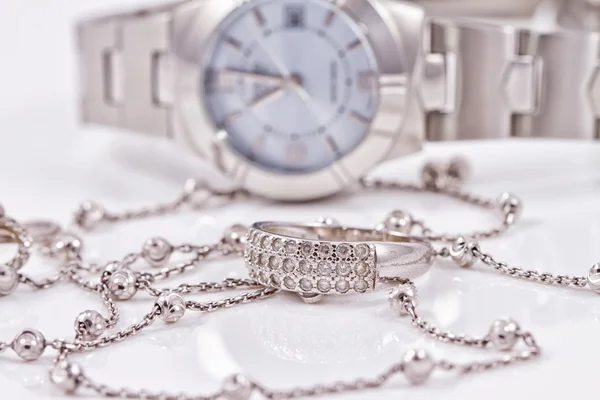 Silver ring and chain on the background of watches