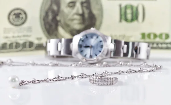 Silver ring and chain on the background of watches