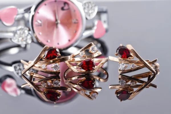 Gold earrings and rings with red rubies and watch