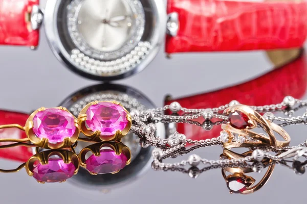 Gold earrings and rings with red rubies and watch