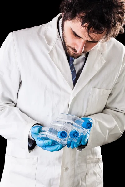 Biologist holding culture flasks