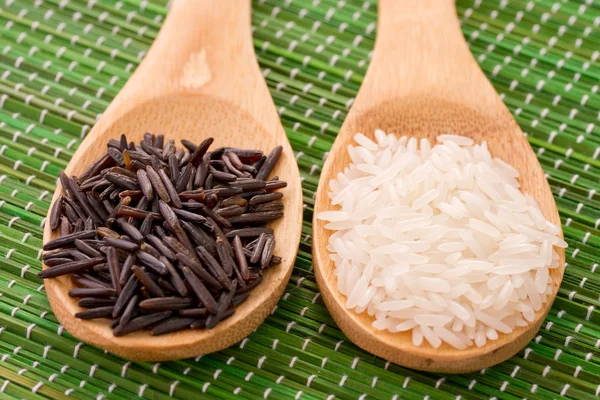 Two wooden spoons with black and white rice