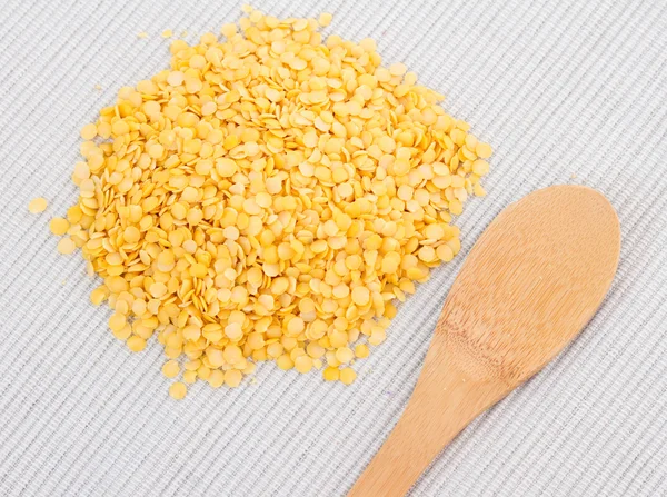 Wooden spoon with yellow lentils