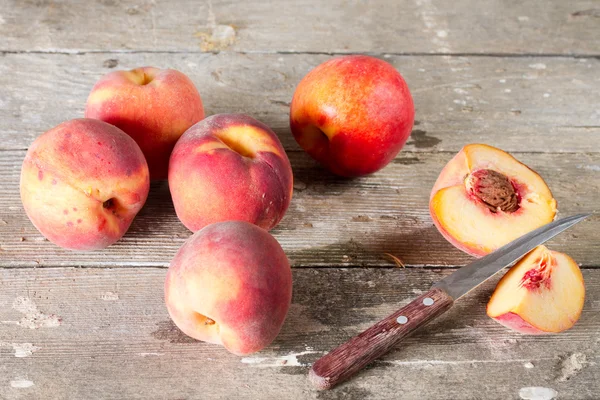 Juicy peaches and knife with wooden handle