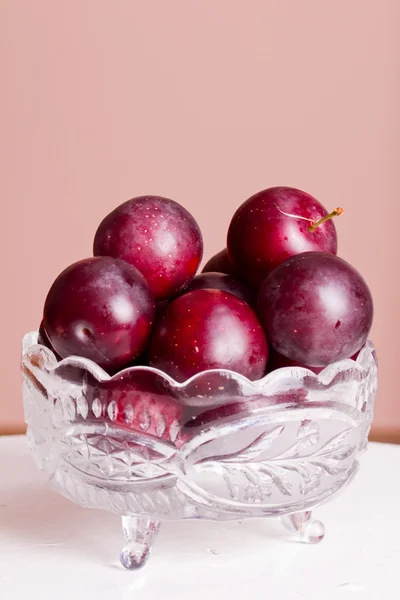 Ripe plums and cherry-plum on a white table