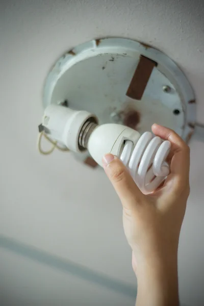 Hand changing light bulb.