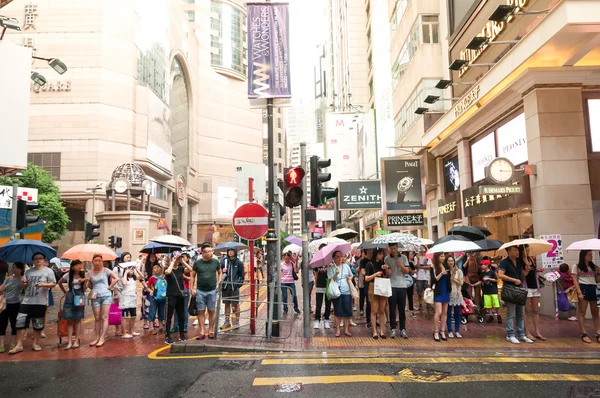 People waiting to cross through busy streets at Hong Kong Times