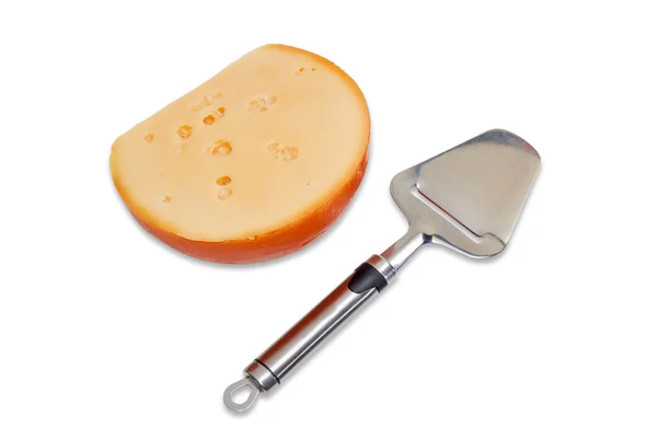 Piece of cheese and cheese slicer on a light background