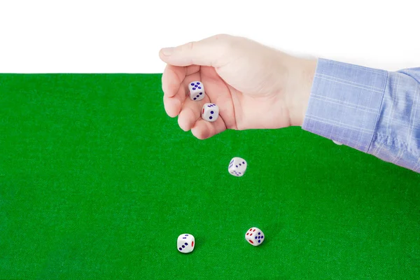 Dice thrown from male hand on table with green cloth