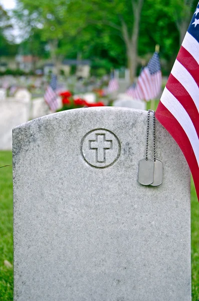 Military dog tags on veteran's grave