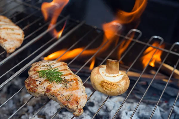 Steaks and mushrooms on grill