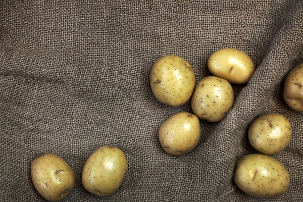 Decorative composition with fresh potatoes.