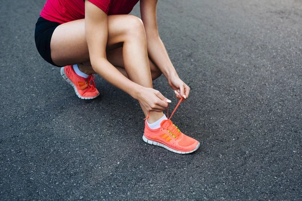 Female runner lacing her shoes