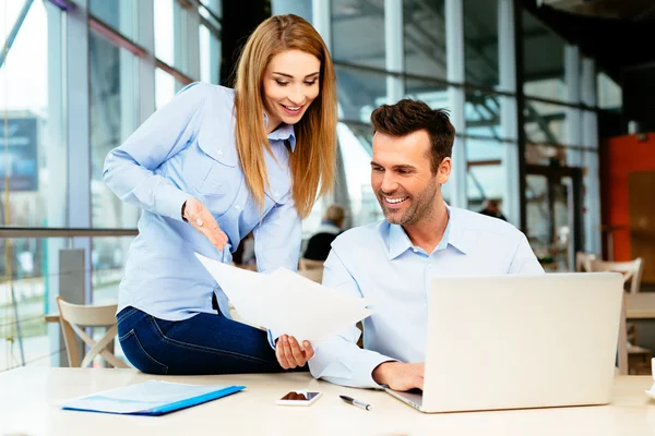 Two professionals looking at sales figures