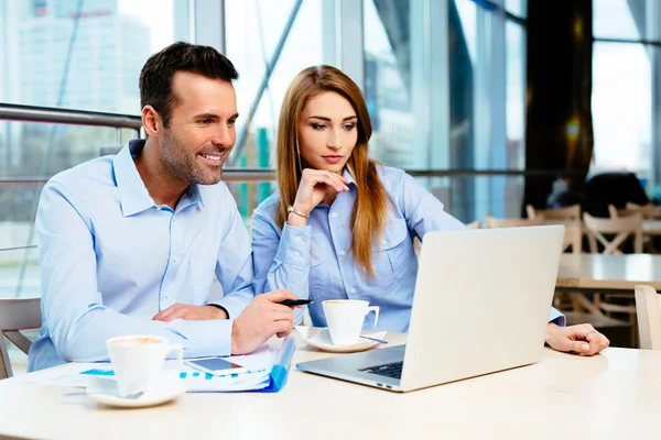 Two young professionals looking at a laptop screen