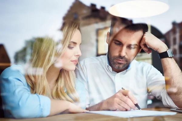 Couple at cafe reading bank contract