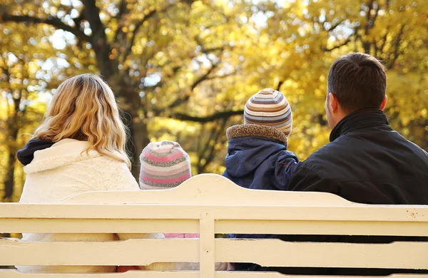 Family sitting on  bench in park