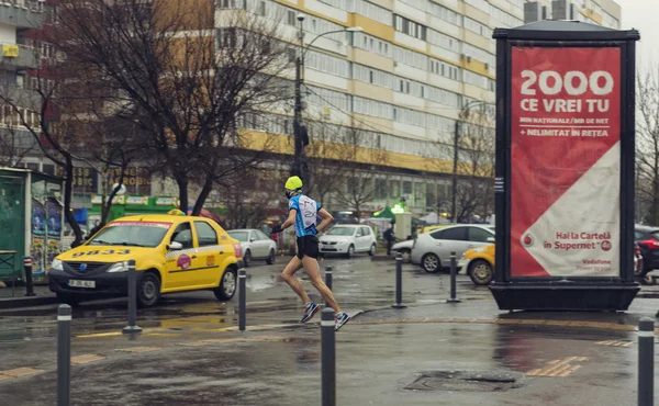 Young man running in the rain on the streets of Bucharest