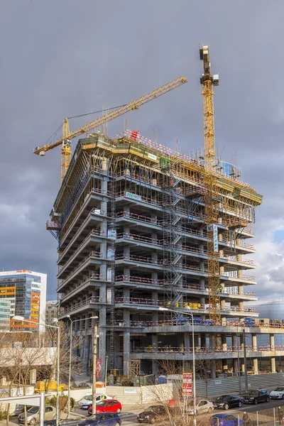 Large cranes working in construction site building new office bu