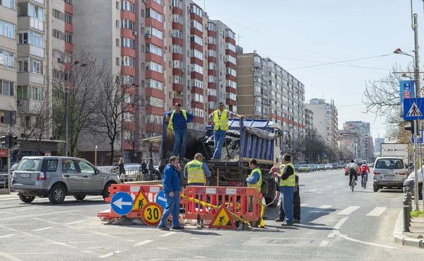 Workers repairing potholes on a main street in Bucharest