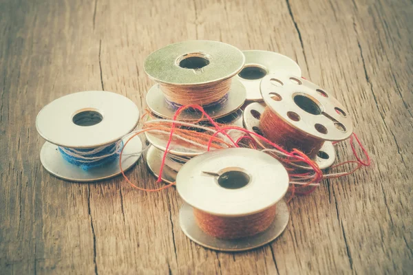 Thread rolls on wood background with filter effect retro vintage