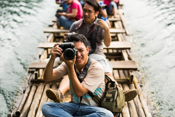 Taking photo while travel on bamboo raft